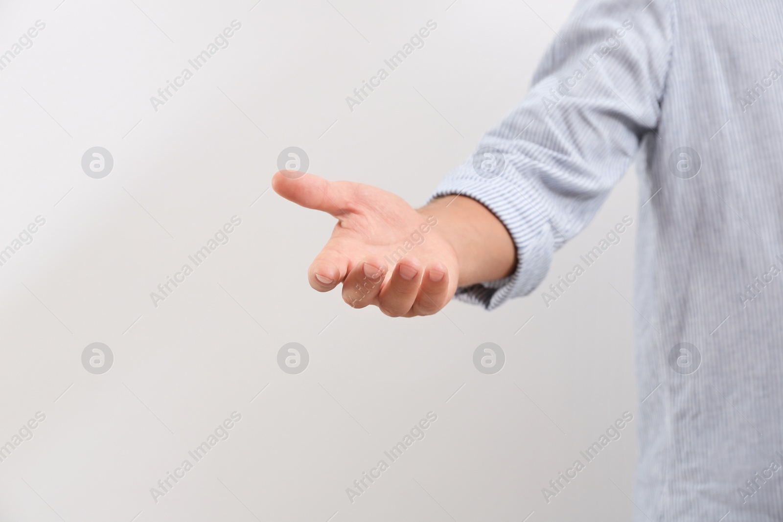 Photo of Man giving helping hand on light background