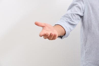 Man giving helping hand on light background