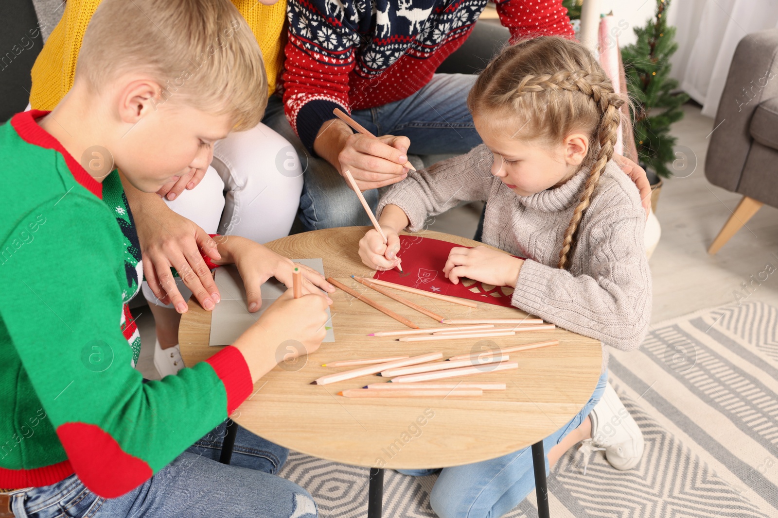 Photo of Cute children with their parents making beautiful Christmas greeting cards at home