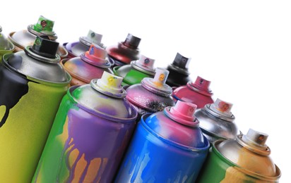 Photo of Used cans of spray paints on white background, closeup. Graffiti supplies