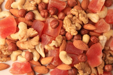 Different tasty nuts and dried papayas as background, top view