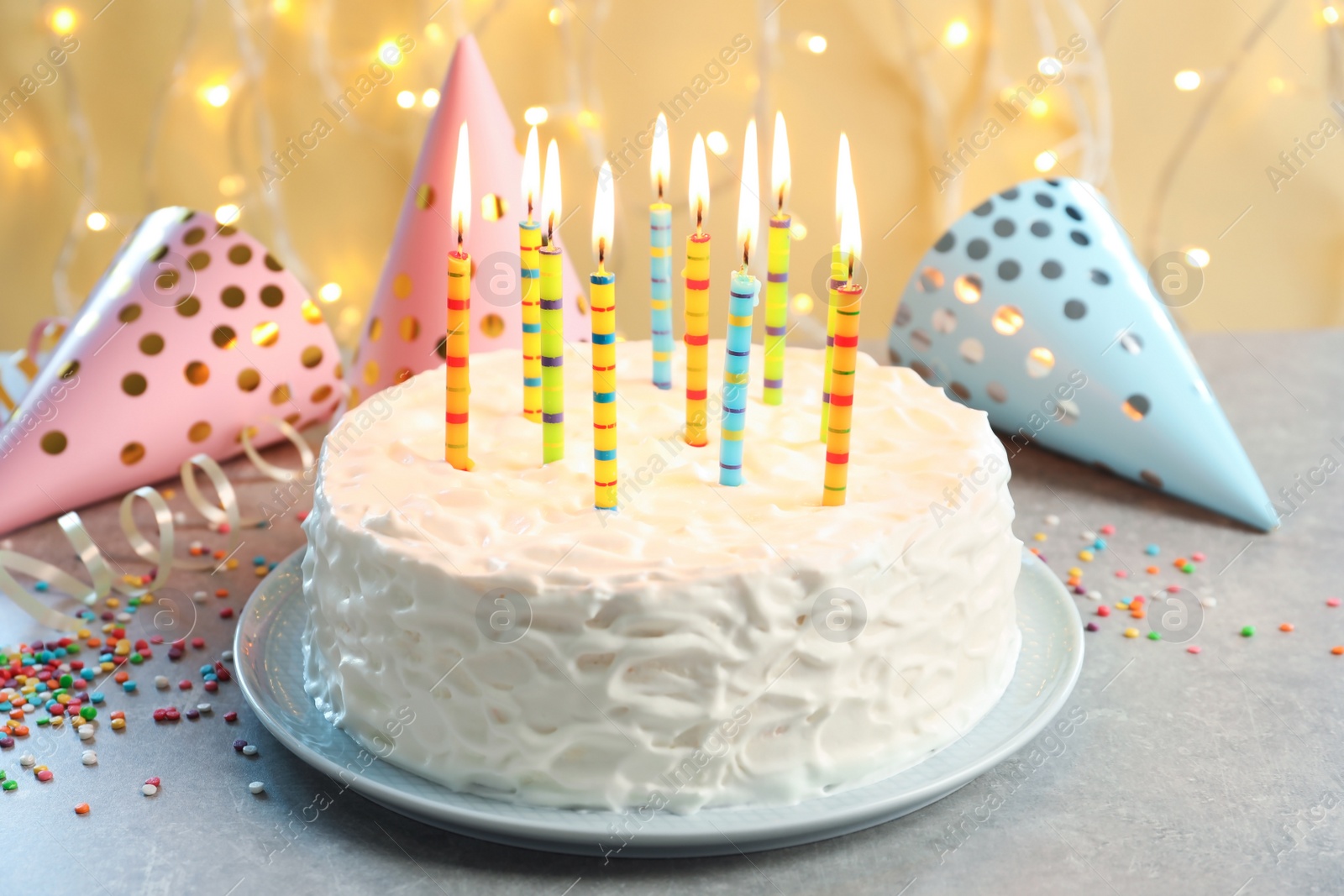 Photo of Delicious birthday cake with burning candles on table