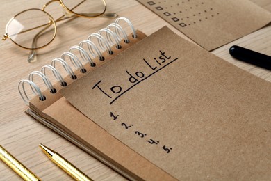 Photo of Notepad and sheet with unfilled To Do list on wooden table, closeup