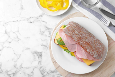 Photo of Tasty sandwich with ham served on white marble table, flat lay. Space for text