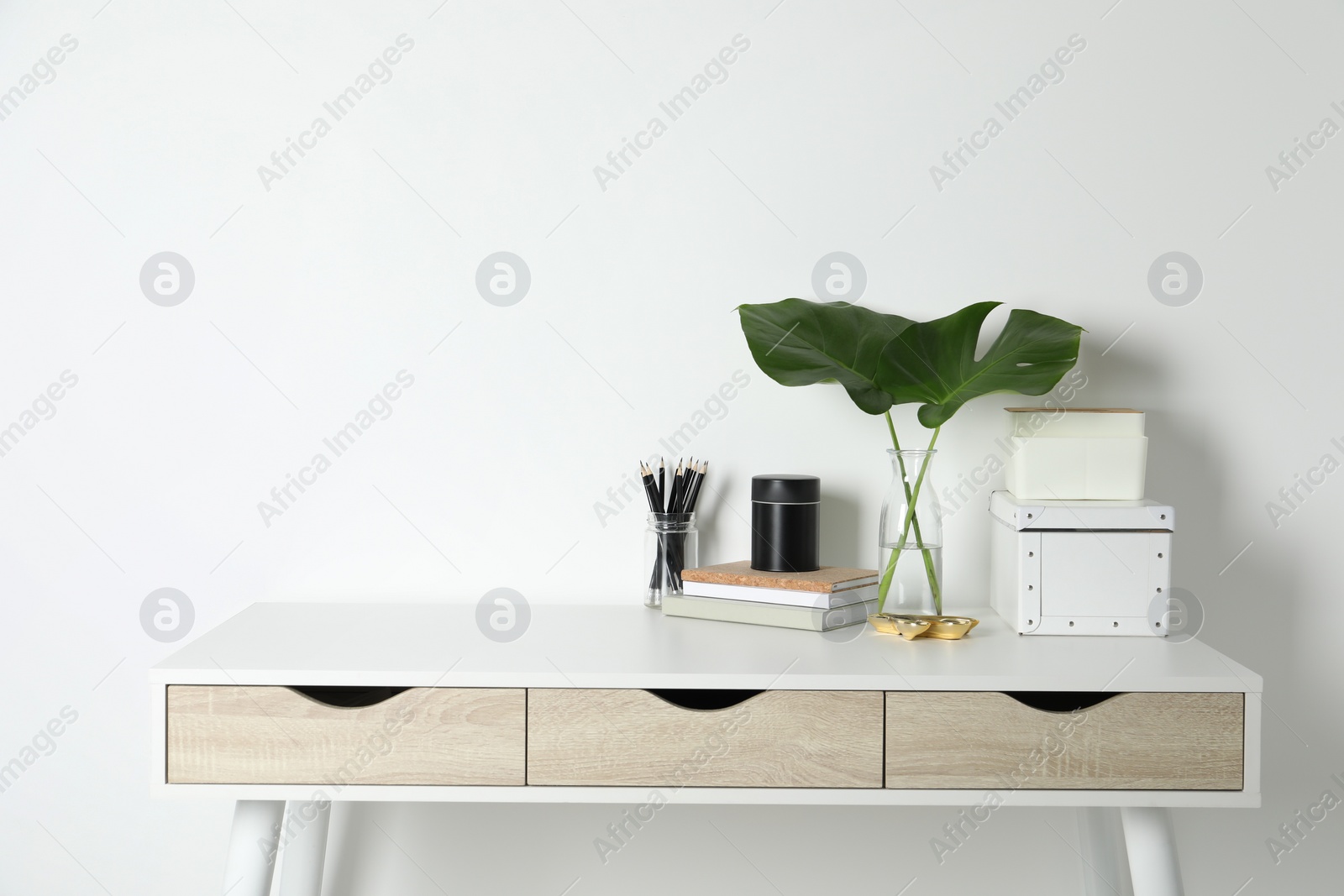 Photo of Comfortable workplace with white desk near wall. Space for text