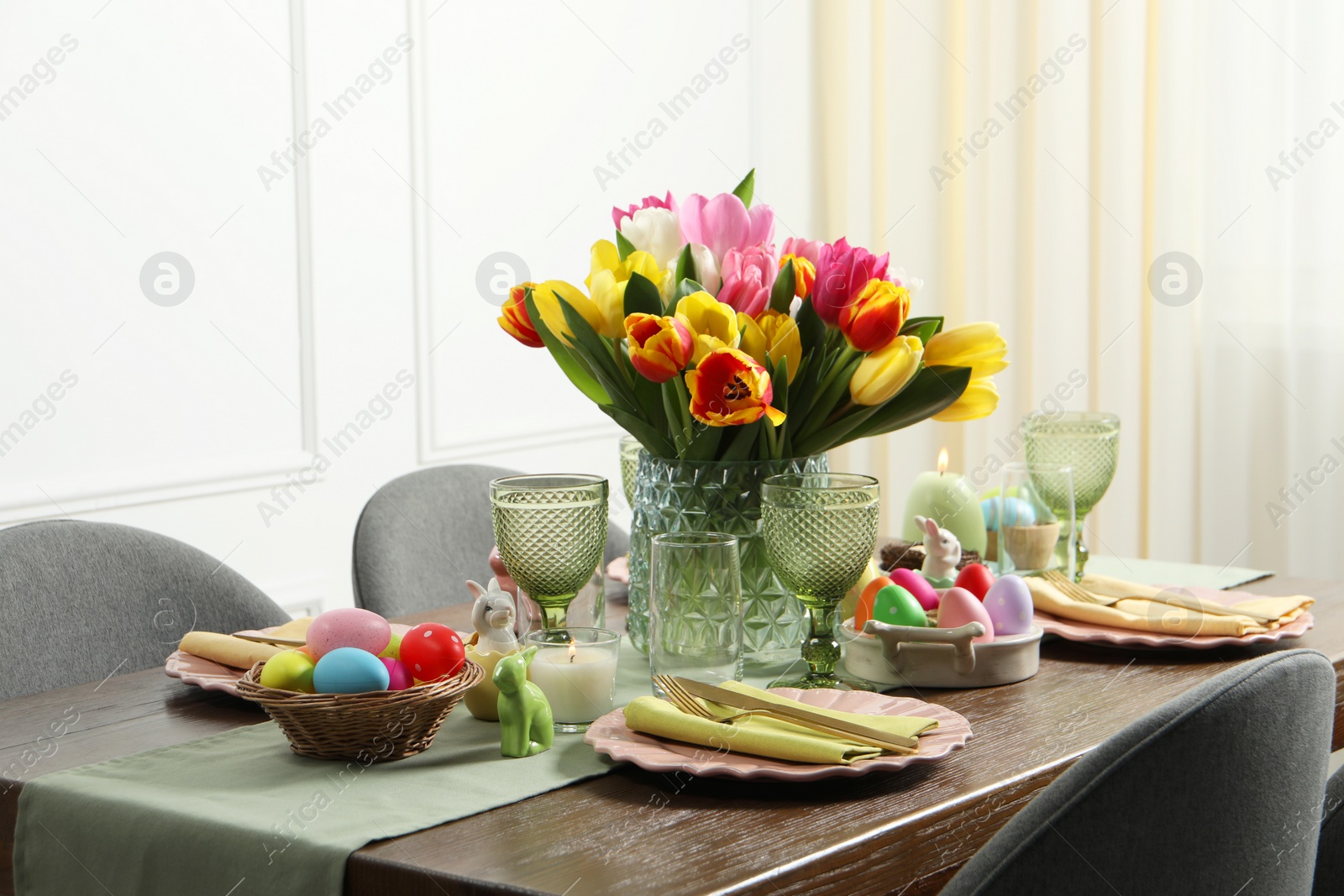 Photo of Easter celebration. Festive table setting with beautiful flowers and painted eggs