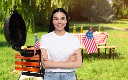 Image of 4th of July - Independence day of America. Happy woman with national flags of United States having picnic in park