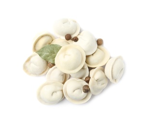 Photo of Pile of raw dumplings with bay leaf and pepper on white background, top view