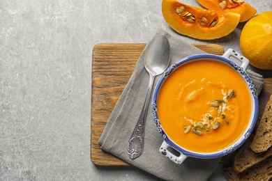 Photo of Flat lay composition with bowl of pumpkin soup and space for text on table