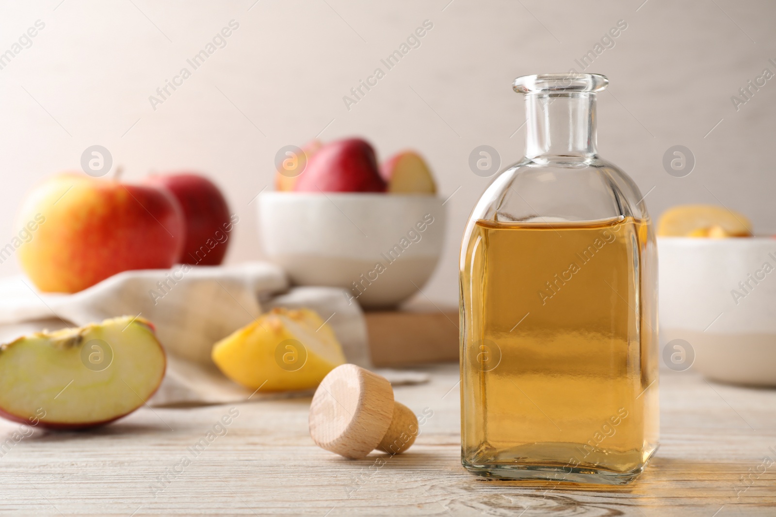 Photo of Composition with bottle of apple vinegar on table. Space for text