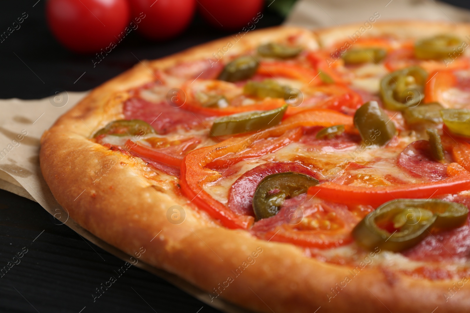 Photo of Delicious pizza Diablo on black wooden table, closeup