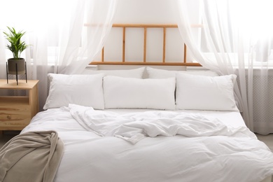 Photo of Comfortable bed with soft pillows in room interior