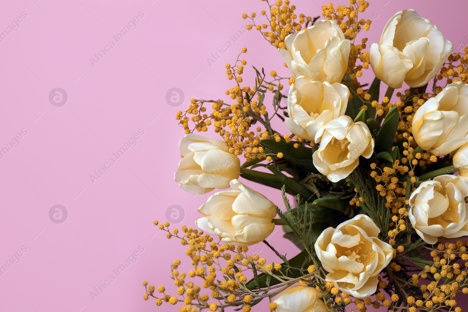 Photo of Bouquet with beautiful tulips and mimosa flowers on pink background. Space for text