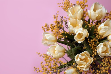 Photo of Bouquet with beautiful tulips and mimosa flowers on pink background. Space for text