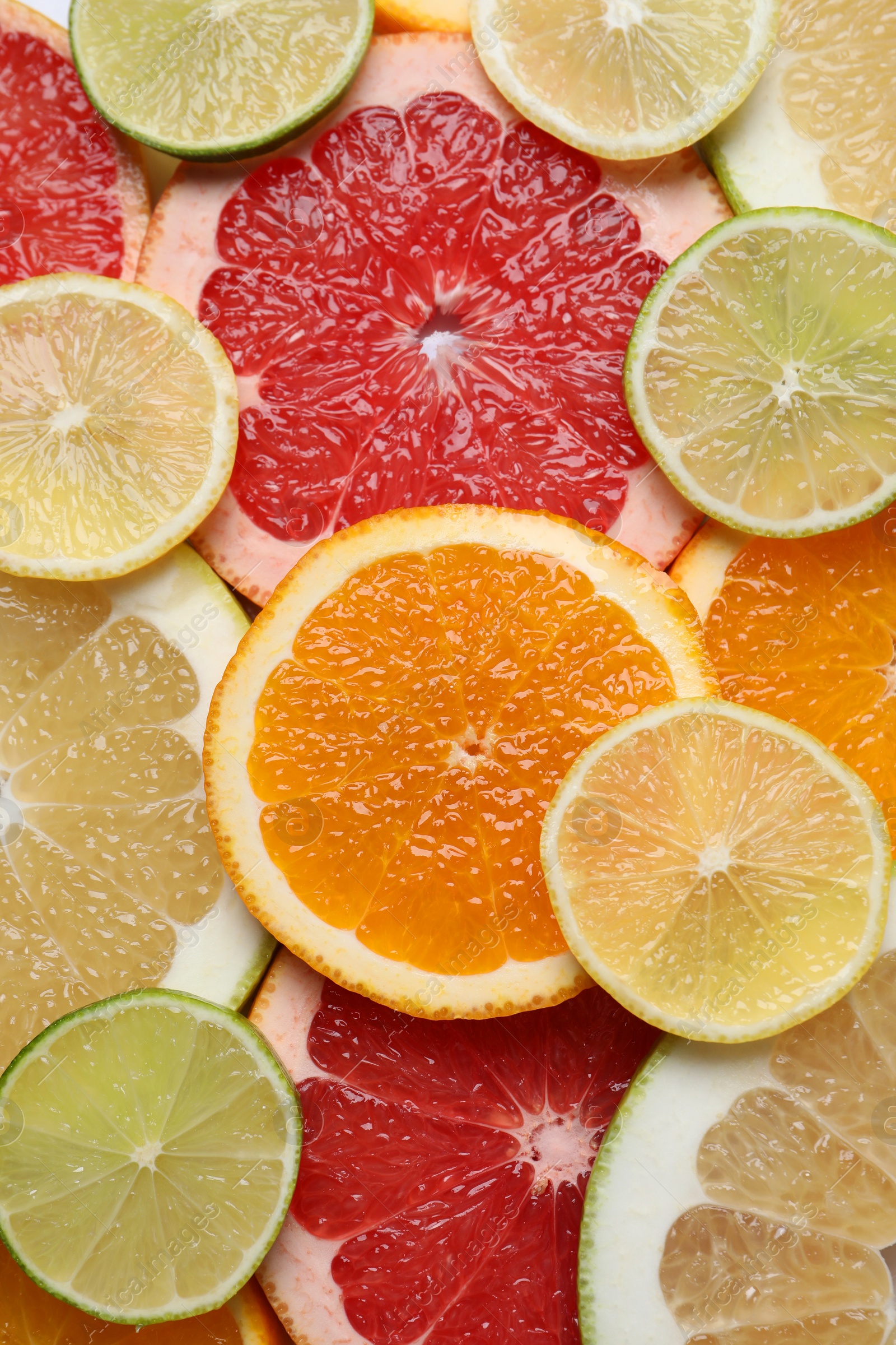 Photo of Slices of different citrus fruits as background, top view