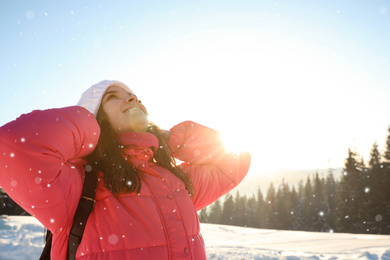 Photo of Young woman having fun outdoors on snowy winter day. Space for text