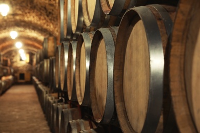 Photo of Large wooden barrels in wine cellar, closeup