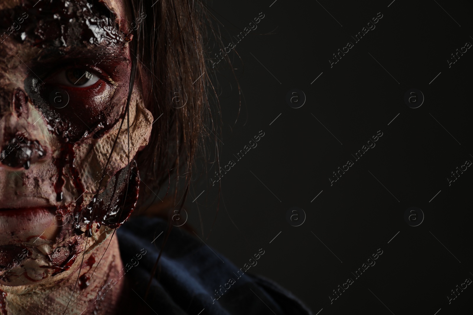 Photo of Scary zombie on dark background, closeup with space for text. Halloween monster