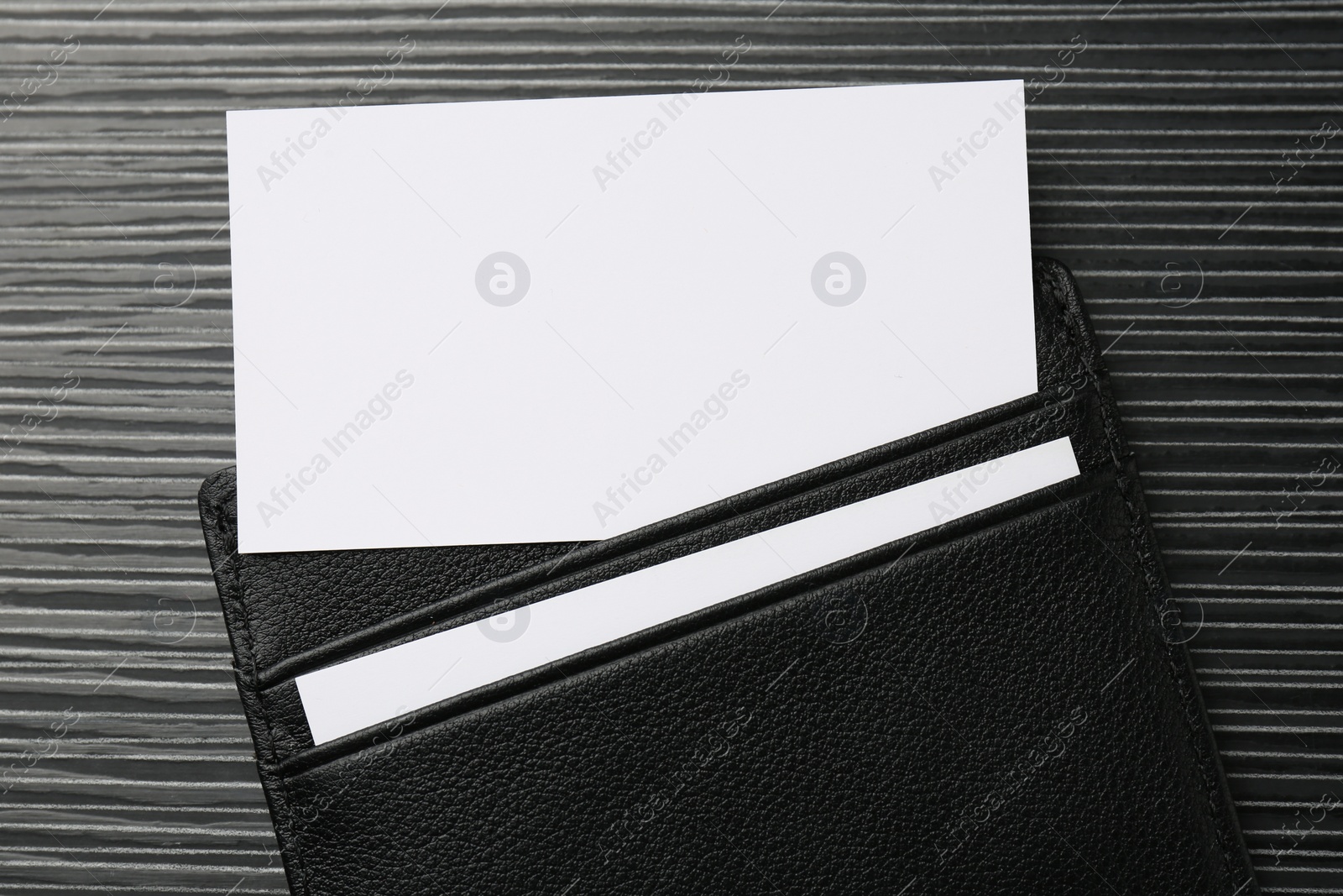Photo of Leather business card holder with blank cards on grey table, top view