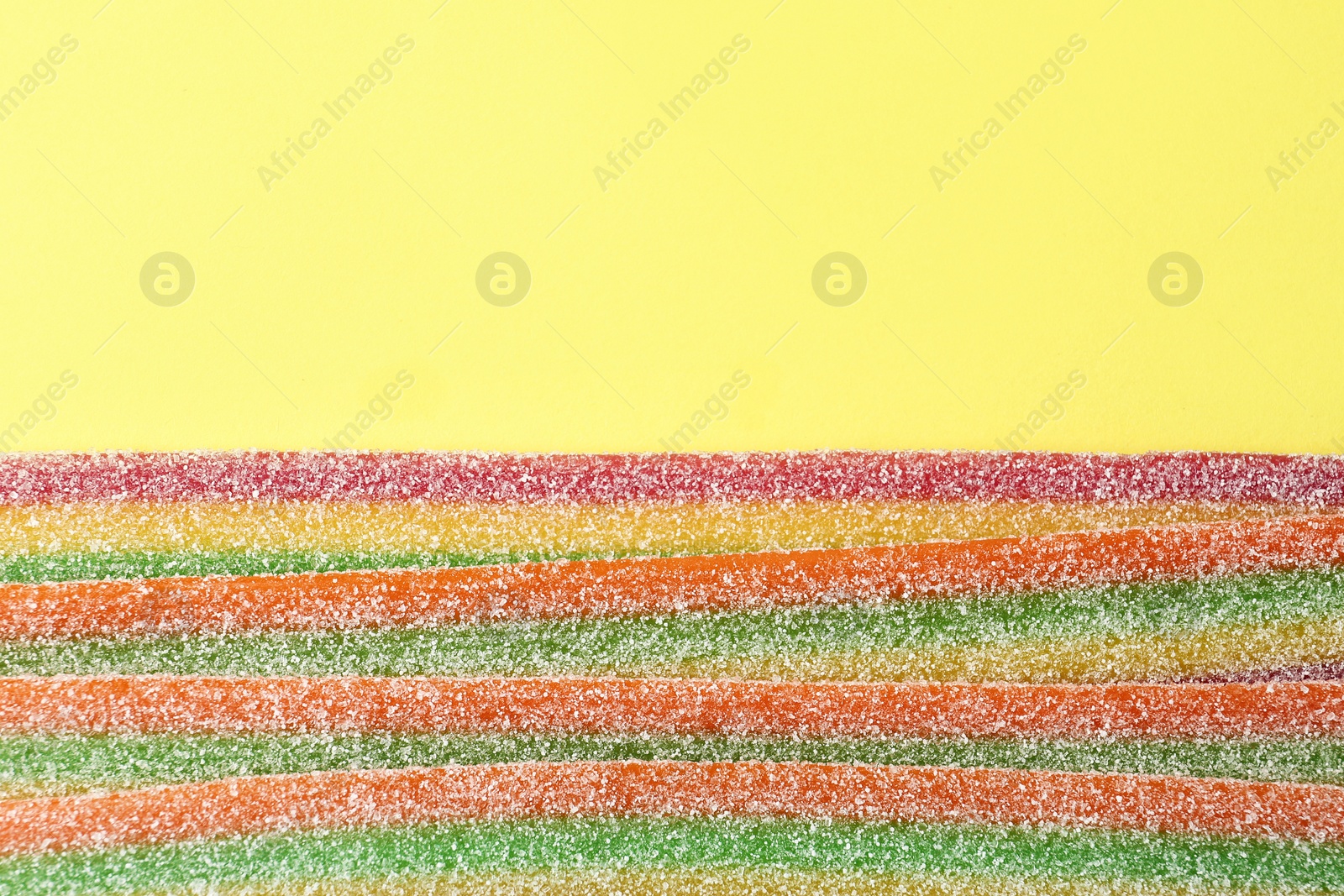 Photo of Tasty jelly candies on color background, top view with space for text