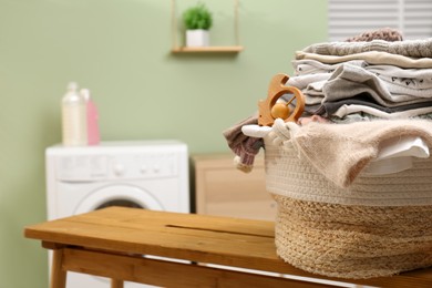 Laundry basket with baby clothes and toy on table in bathroom, closeup. Space for text