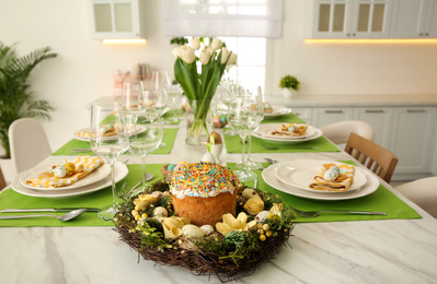 Photo of Festive table setting with traditional Easter bread indoors