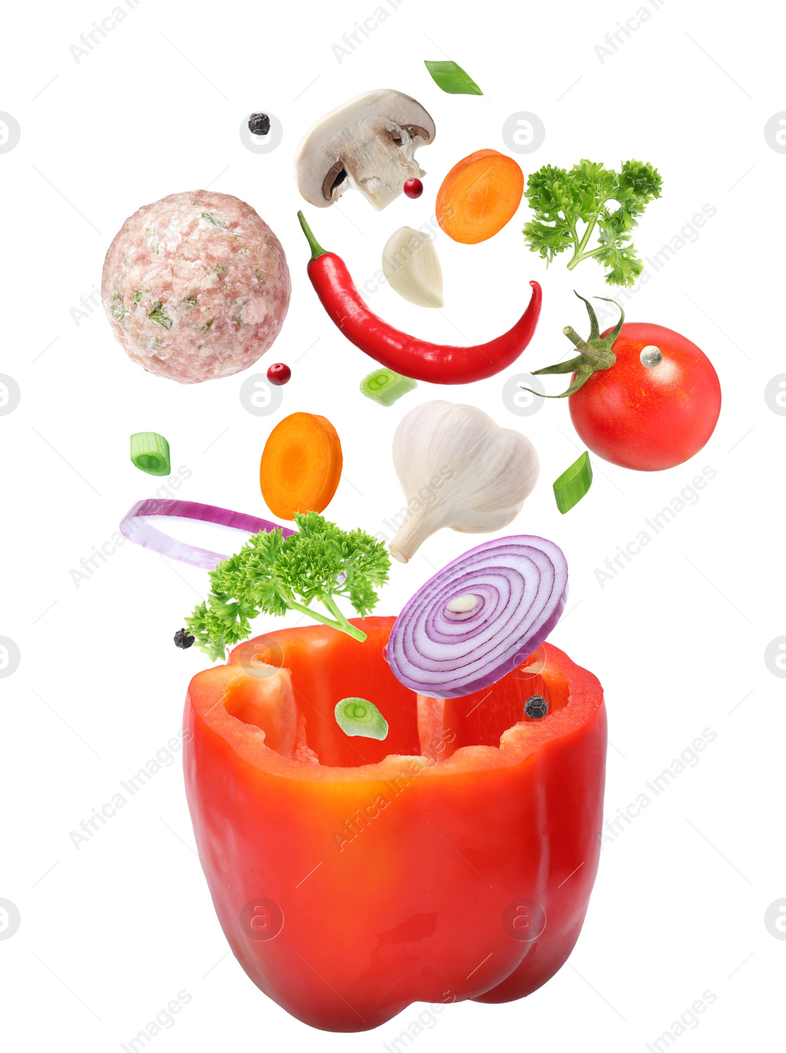 Image of Stuffed pepper recipe. Fresh ingredients falling into bell pepper on white background