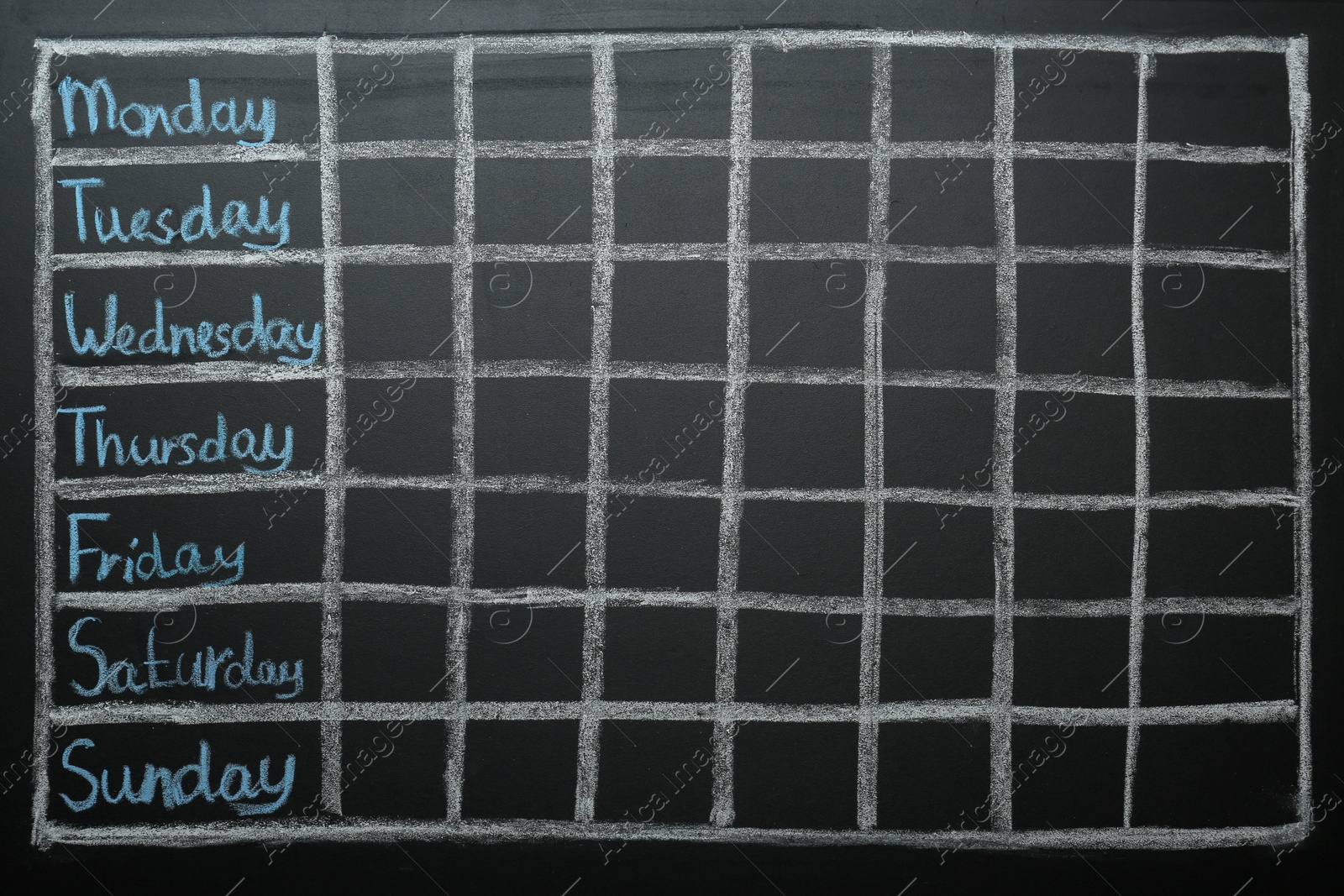 Photo of Weekly school timetable drawn on black chalkboard