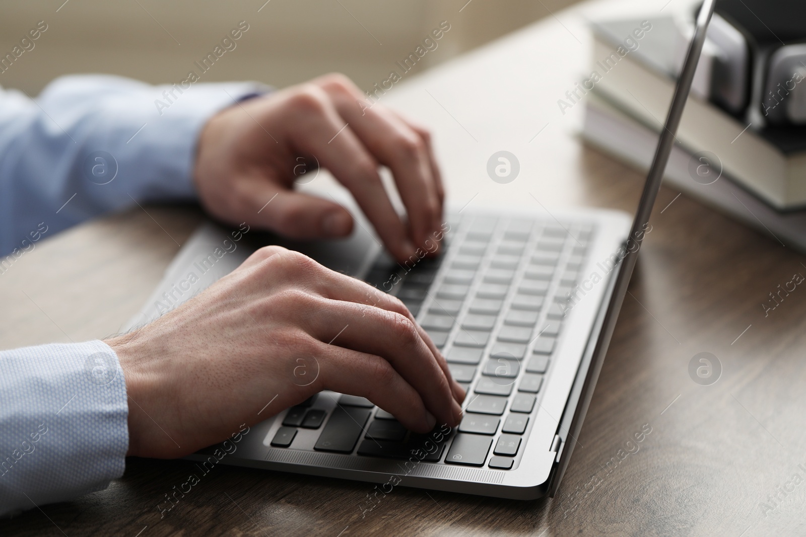 Photo of E-learning. Man using laptop during online lesson at table indoors, closeup
