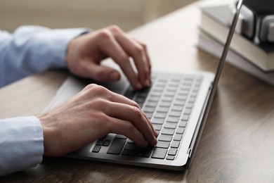 E-learning. Man using laptop during online lesson at table indoors, closeup