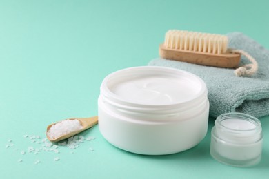 Photo of Jars of cream and body care products on turquoise background