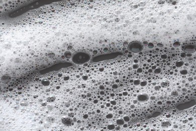 White washing foam on dark gray background, top view