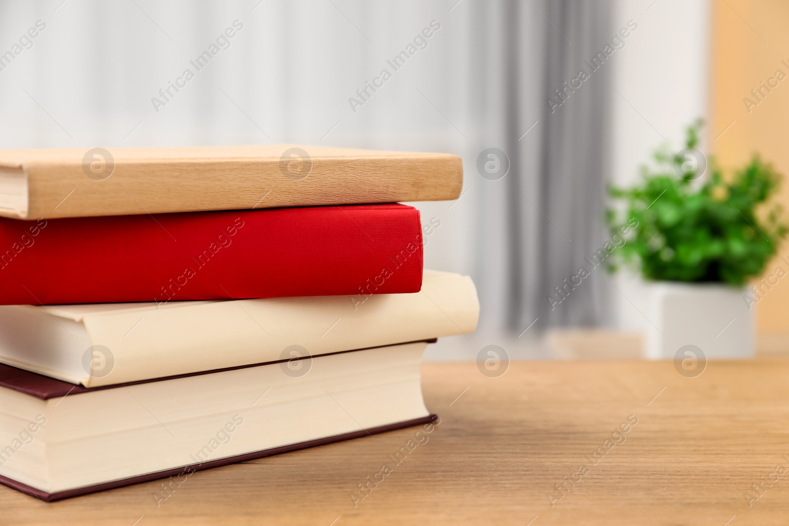 Photo of Stack of hardcover books on wooden table indoors