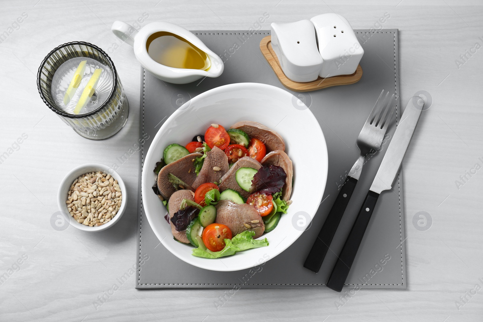 Photo of Delicious salad with beef tongue and vegetables served on white wooden table, flat lay