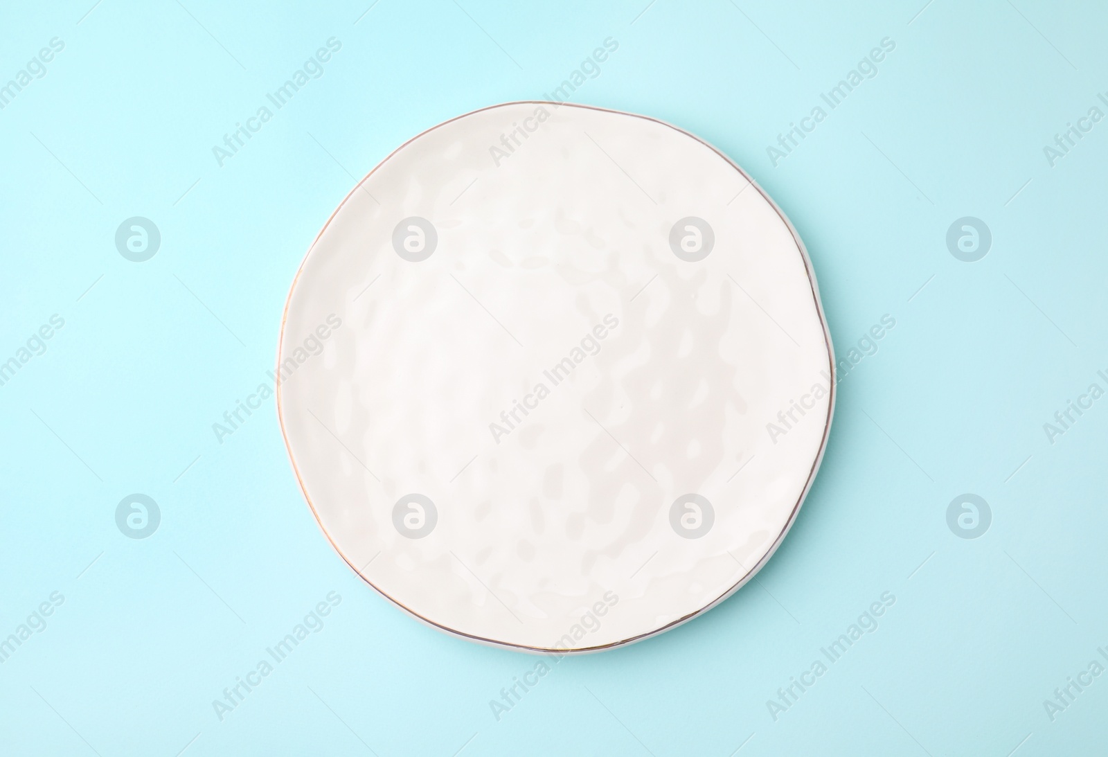 Photo of One clean plate on light blue background, top view