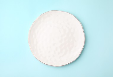 Photo of One clean plate on light blue background, top view