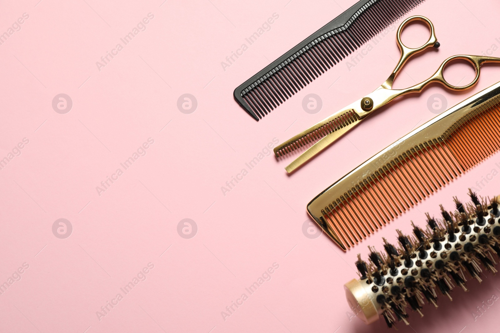 Photo of Professional hair dresser tools on pink background, flat lay. Space for text