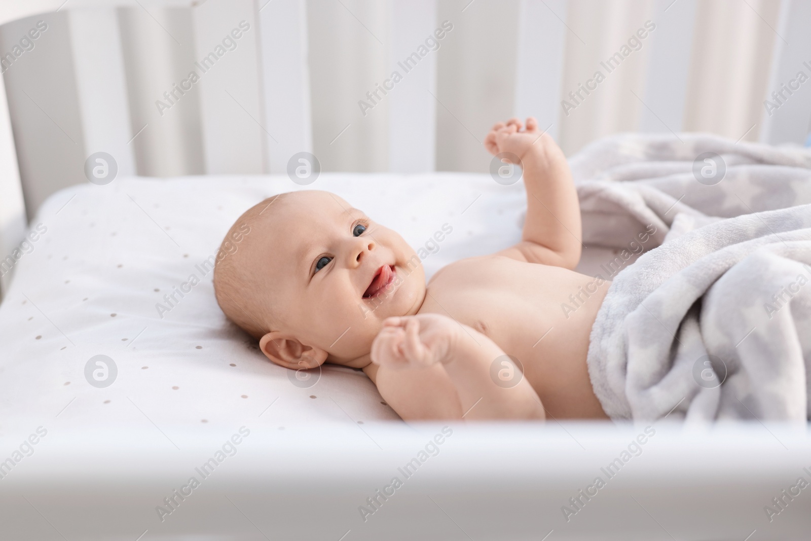 Photo of Cute little baby lying in crib at home