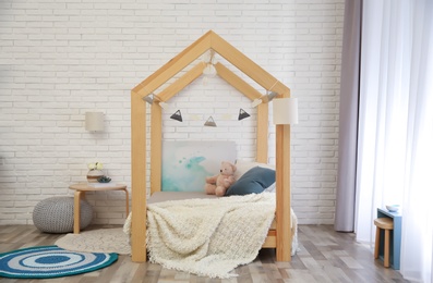Stylish child room interior with cute wooden bed