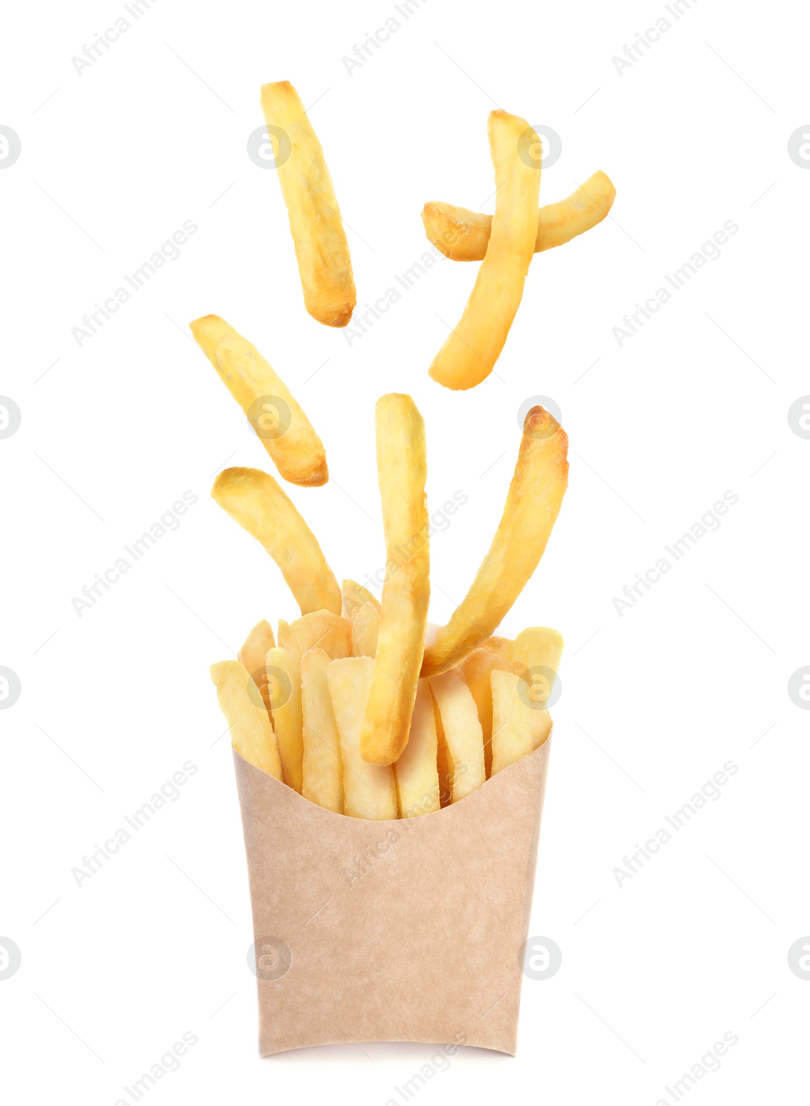 Image of Tasty French fries falling into paper takeaway container on white background