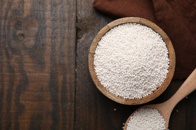 Tapioca pearls in bowl and spoon on wooden table, flat lay. Space for text