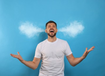 Image of Aggressive man with steam coming out of his ears on light blue background