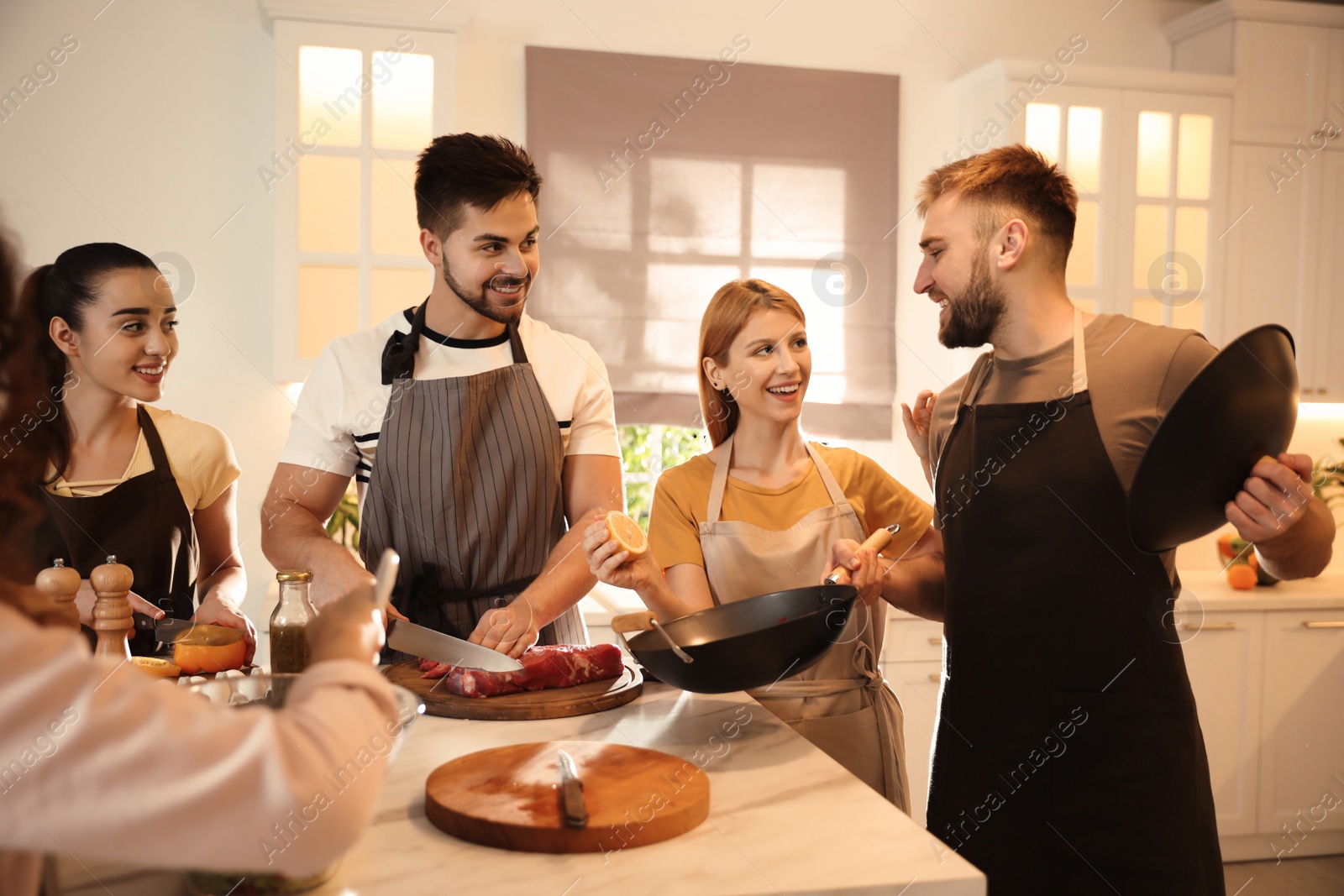 Photo of Happy people cooking food together in kitchen