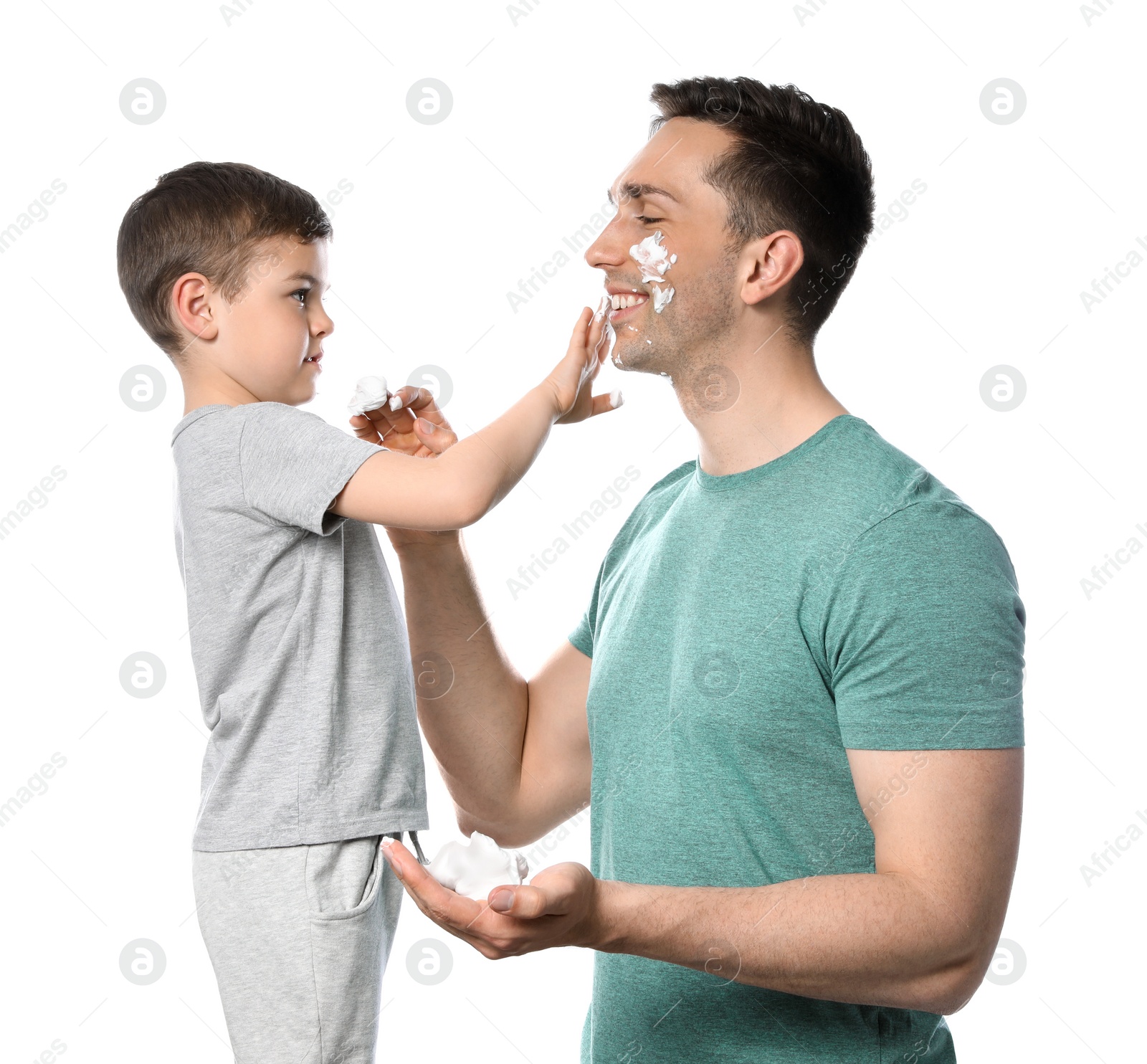 Photo of Dad and his little son applying shaving foam against white background