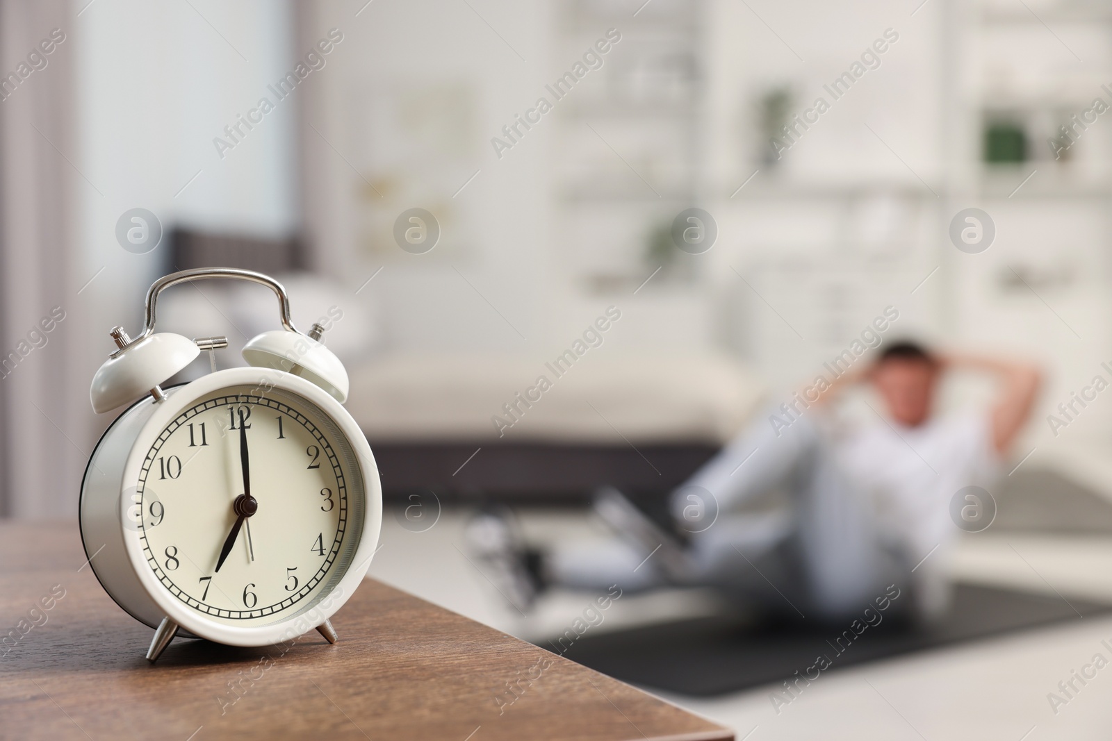 Photo of Man doing morning exercise on fitness mat at home, selective focus. Space for text