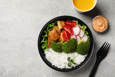 Photo of Healthy takeaway meal served with sauce and juice on light grey table, flat lay. Space for text