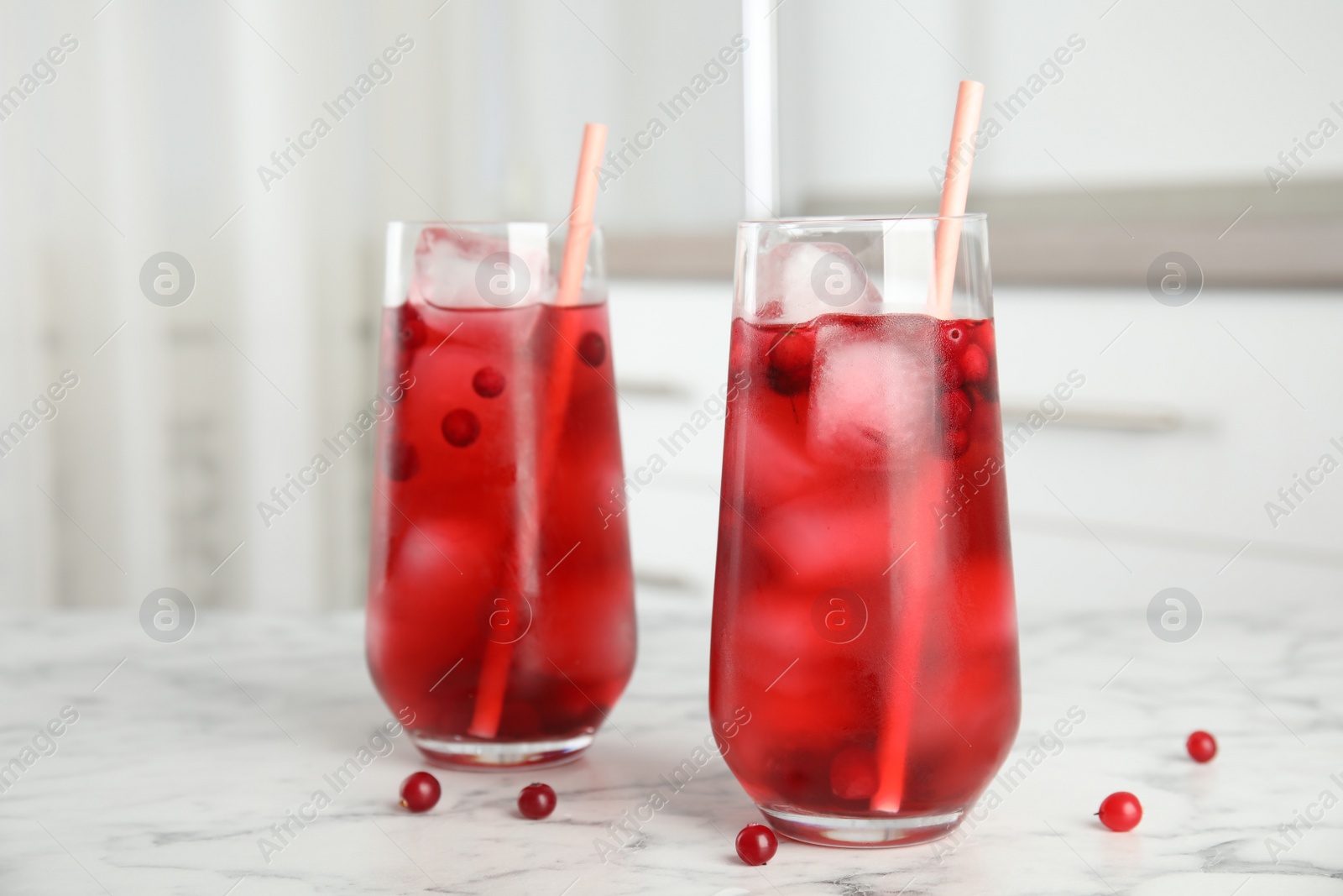 Photo of Tasty refreshing cranberry cocktail on white marble table indoors