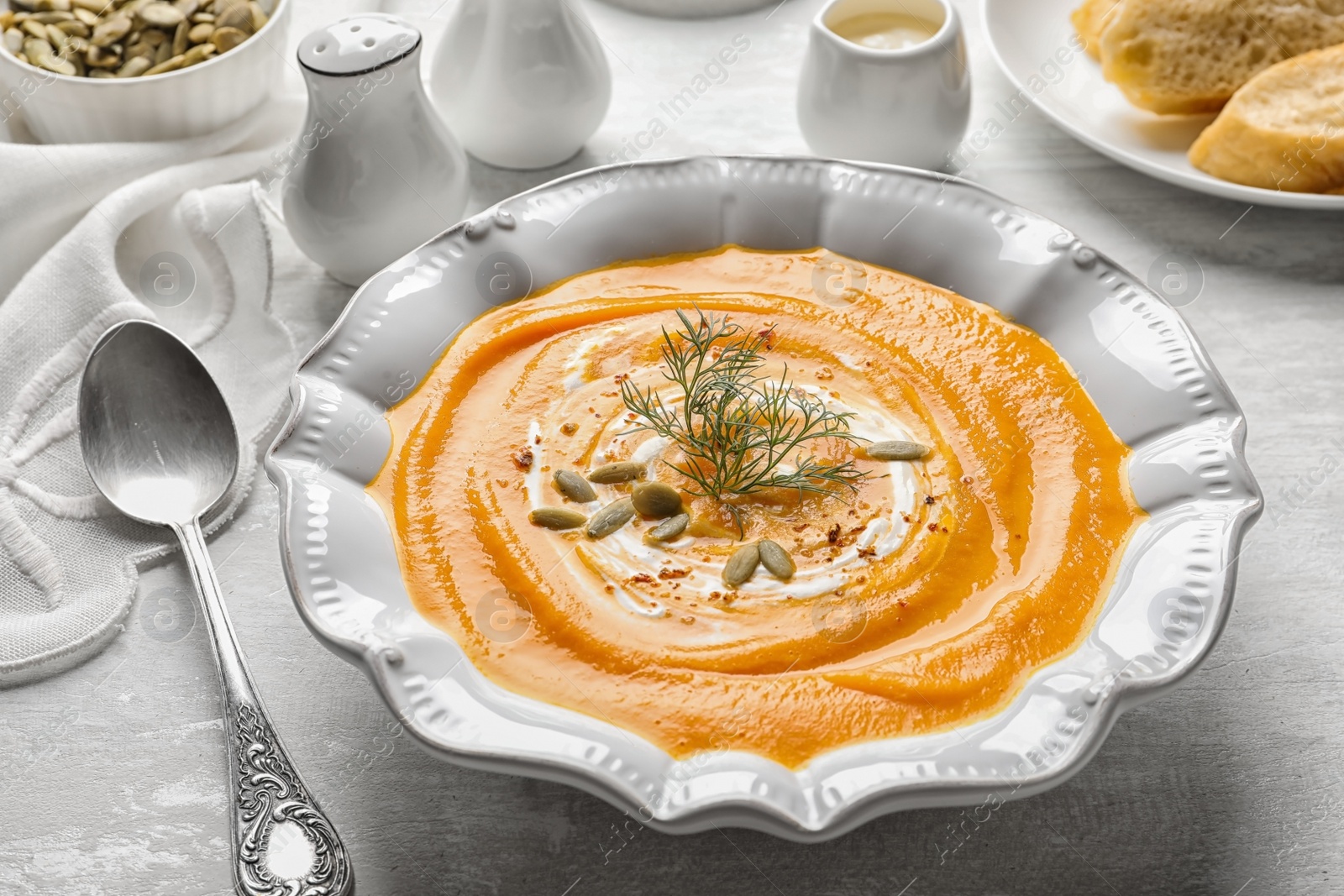 Photo of Plate with tasty pumpkin soup served on table