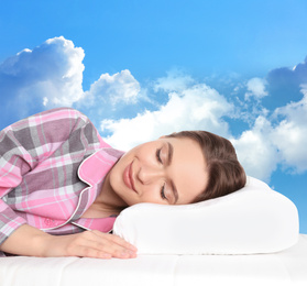 Image of Young woman sleeping on mattress. Blue sky on background