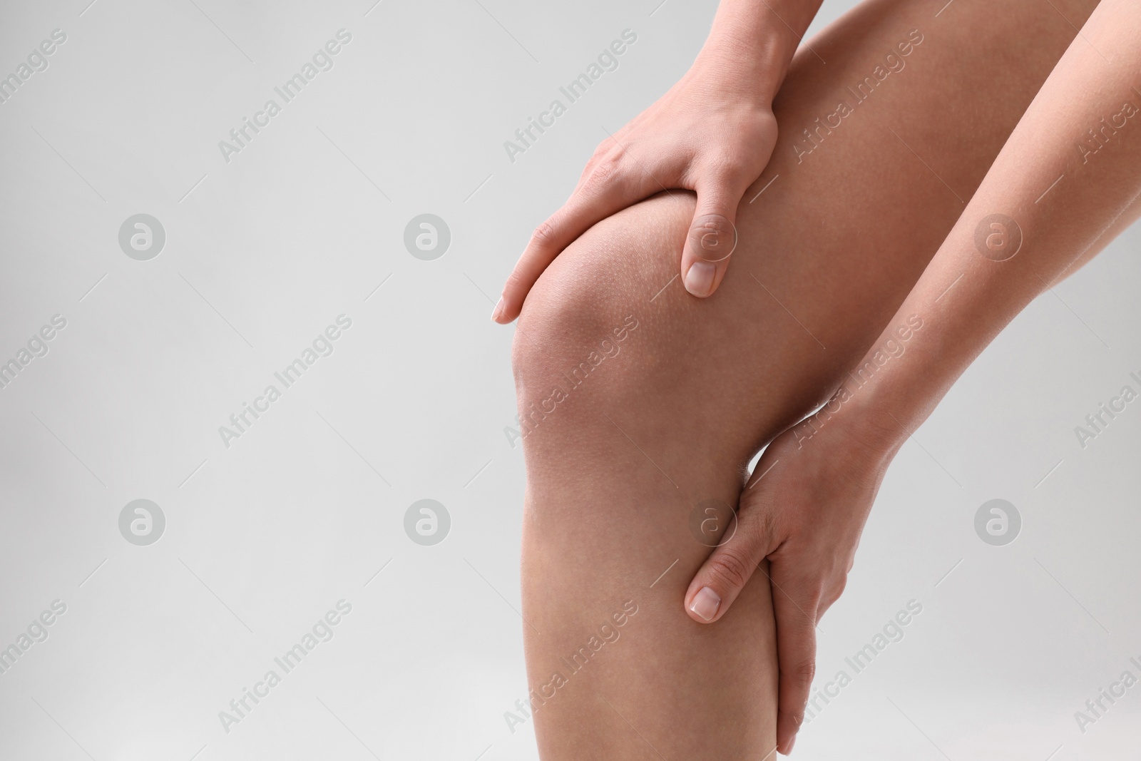 Photo of Woman showing her slim legs on grey background, closeup. Space for text